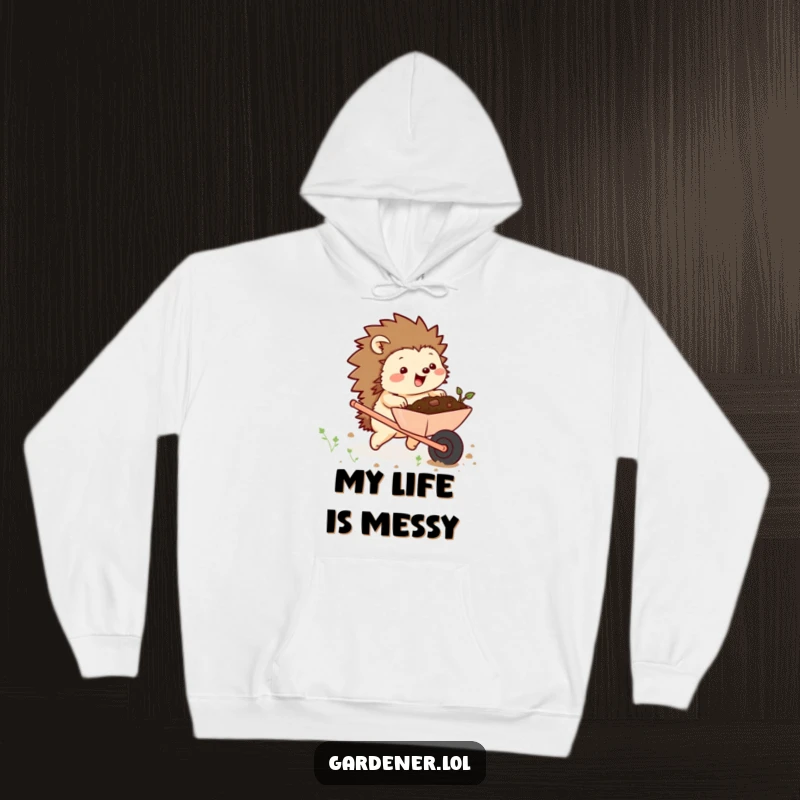 Funny hoodie depicting a chubby hedgehog character excitedly pushing a wheelbarrow full of soil, offering warm, humorous garden vibes.